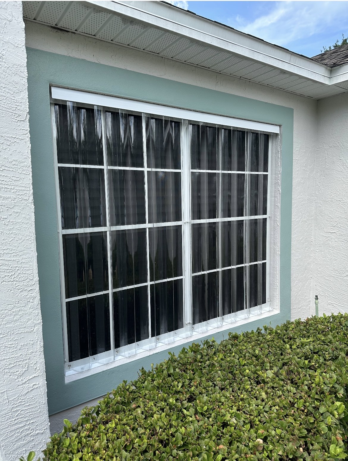 Clear corrugated storm panels fitted over a window
